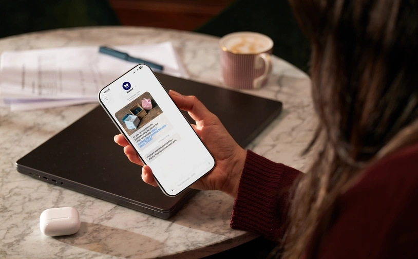 Person working remotely on a laptop while relaxing on a hotel bed in a modern hotel room