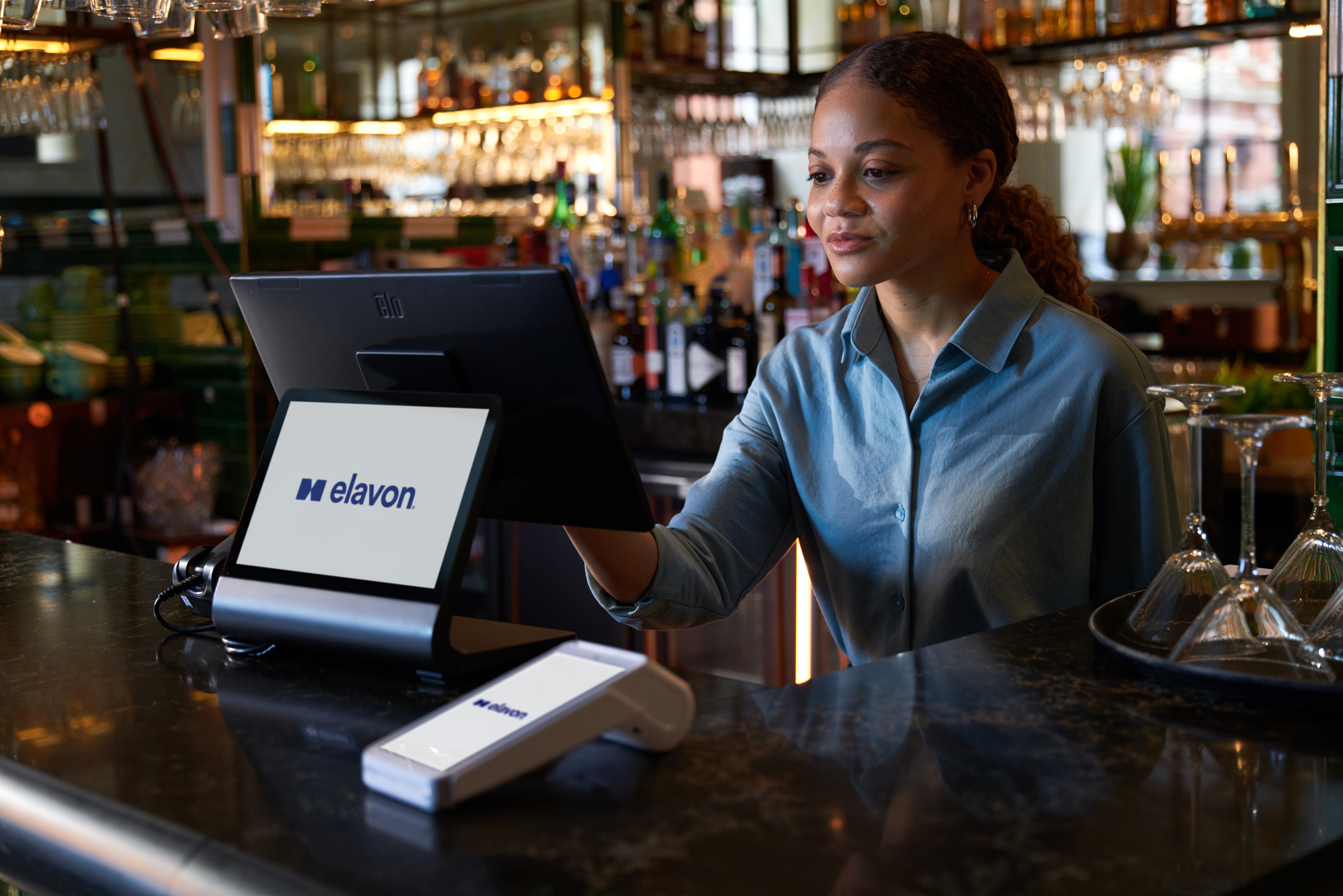 Restaurant staff taking an order using a digital tablet at a professional kitchen pass